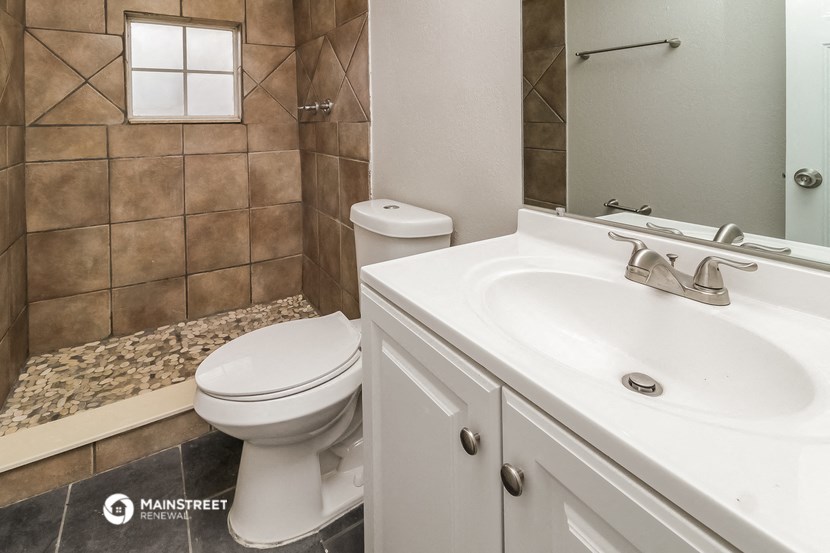a bathroom with a toilet and a sink and a shower