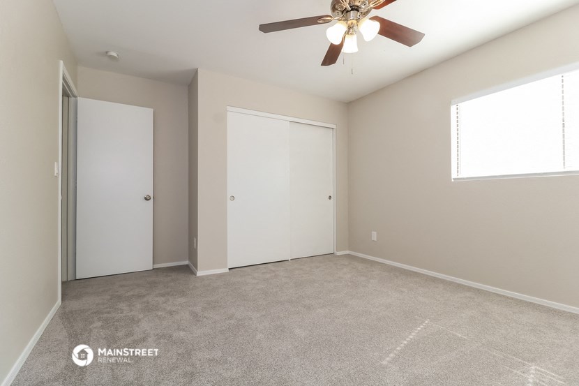 an empty room with a ceiling fan and a closet