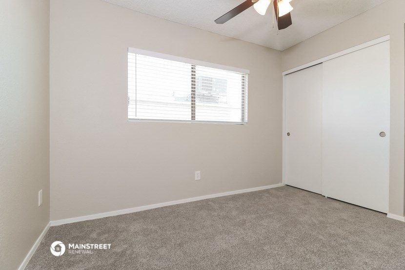 a bedroom with a ceiling fan and a closet