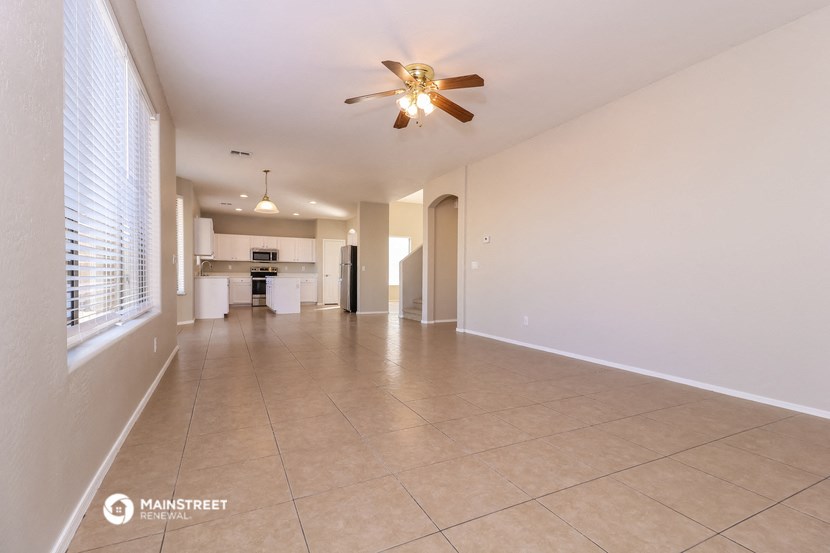 an empty living room with a ceiling fan