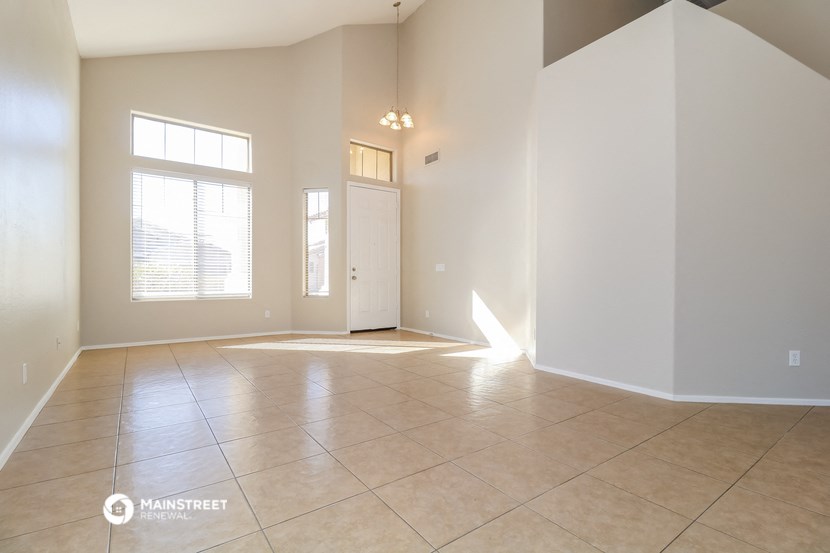 an empty living room with tile floors and a white door