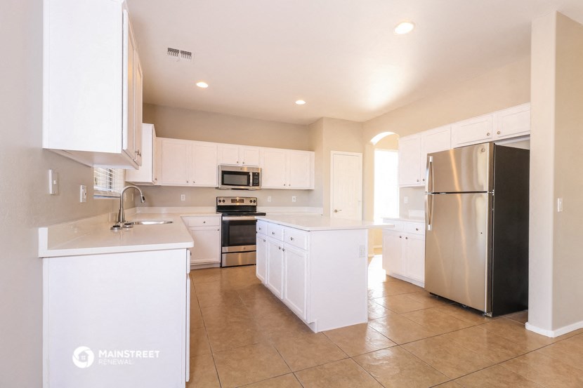 a large kitchen with white cabinets and stainless steel appliances