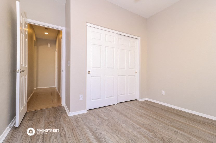 a bedroom with a closet and a door to a hallway