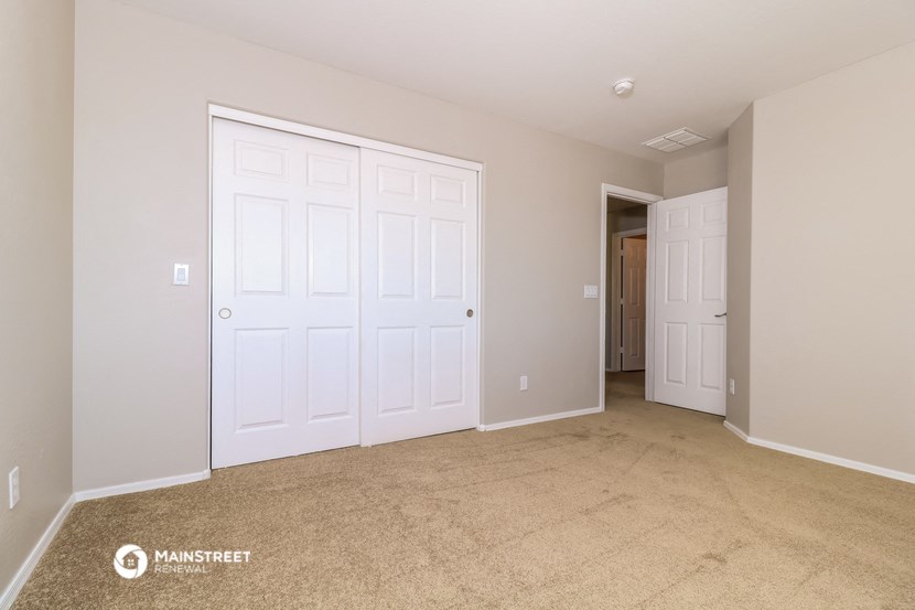 a bedroom with two closets and a carpeted floor