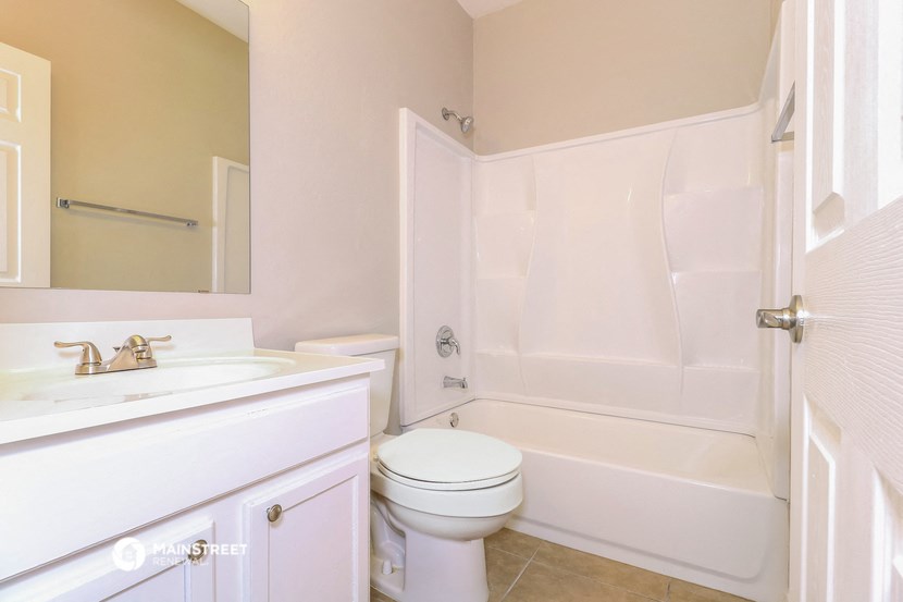 a bathroom with a toilet and a tub and a sink