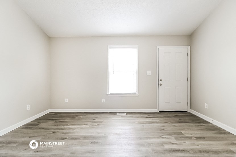 an empty room with white walls and a white door