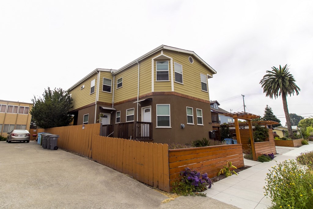 a yellow and brown house with a wooden fence