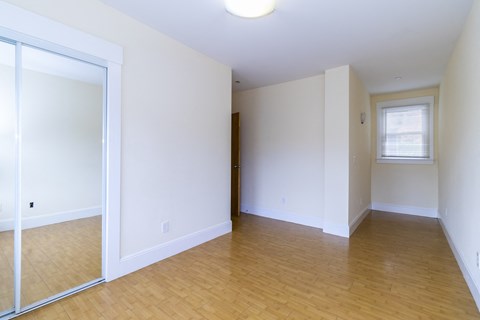 an empty living room with white walls and a sliding glass door