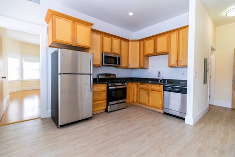 an empty kitchen with wooden cabinets and stainless steel appliances