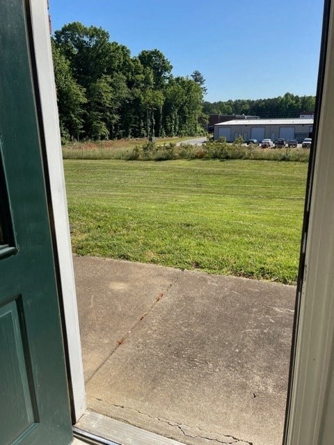 A view from a door looking out to a green field.