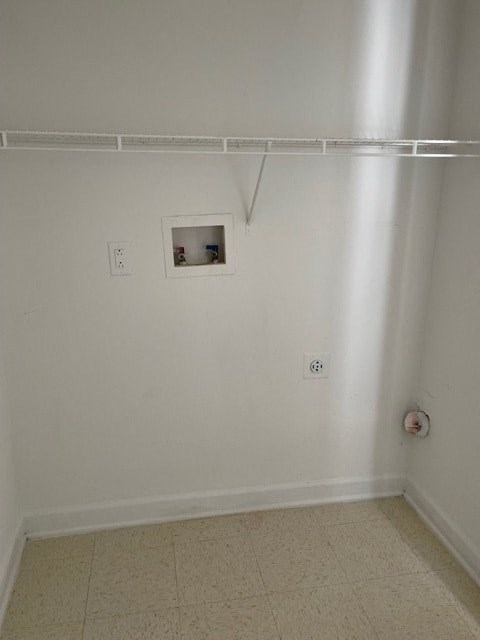 A white wall with a small window and a white floor.