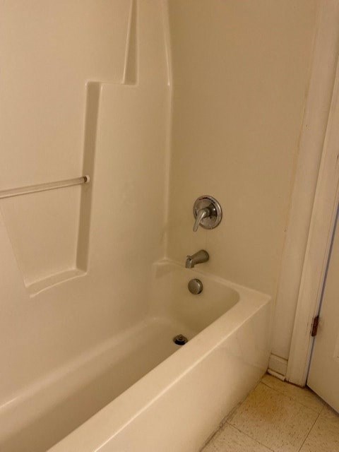 A white bathtub with a silver faucet and a silver handle.