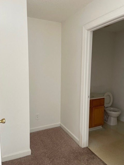 A white door is on the left and a toilet is in the corner on the right.
