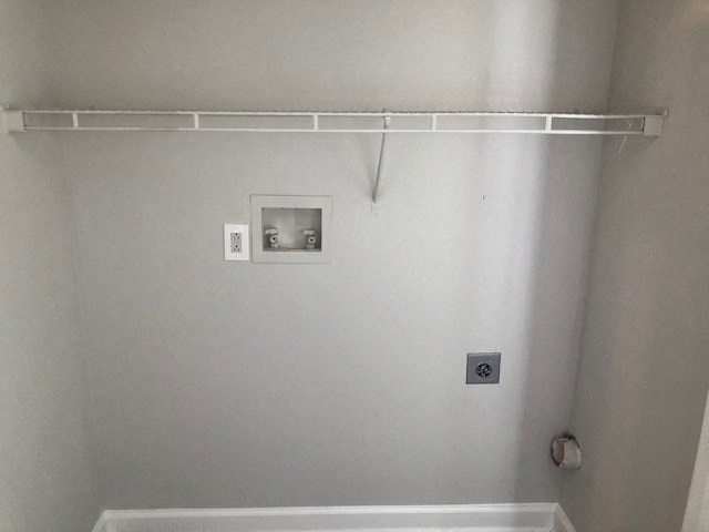 A white wall with a shelf and a picture frame.