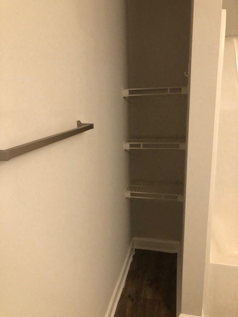 A white wall with a shelf and a doorway.
