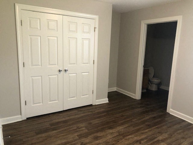 A white door with a small window in the middle is in a room with wood flooring.