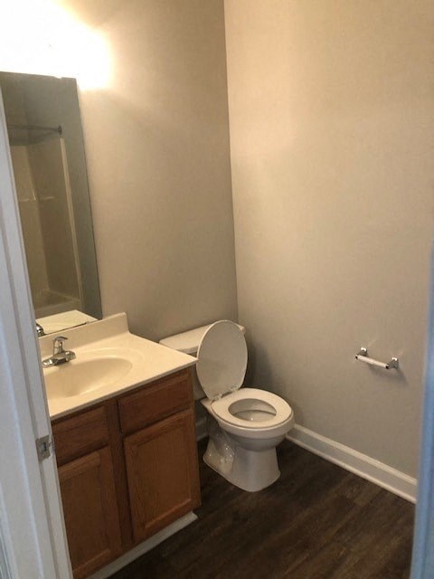 A white toilet in a bathroom with a wooden cabinet and a mirror.