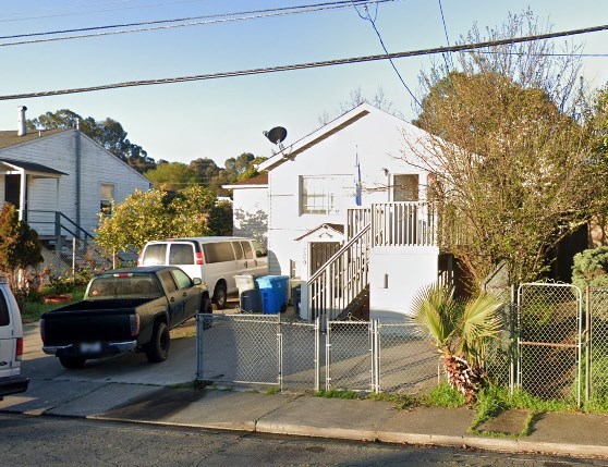 A white house with a black truck parked in front of it.