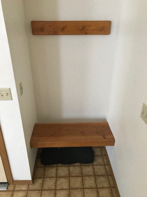 a wooden bench in the corner of a room