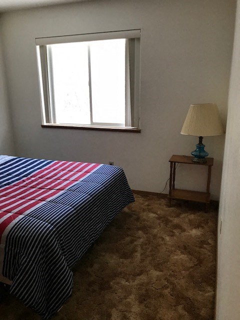 a small bedroom with a bed and a window