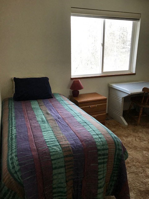 a bedroom with a bed with a striped blanket