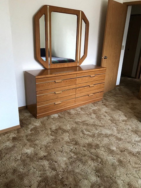 a dresser with a mirror on it in a room