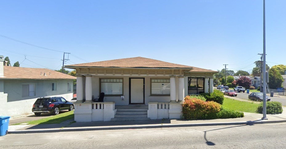 a small house on the corner of a street
