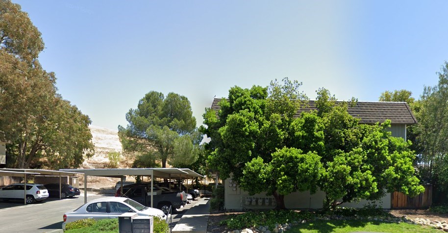 a view of a parking lot with trees and cars