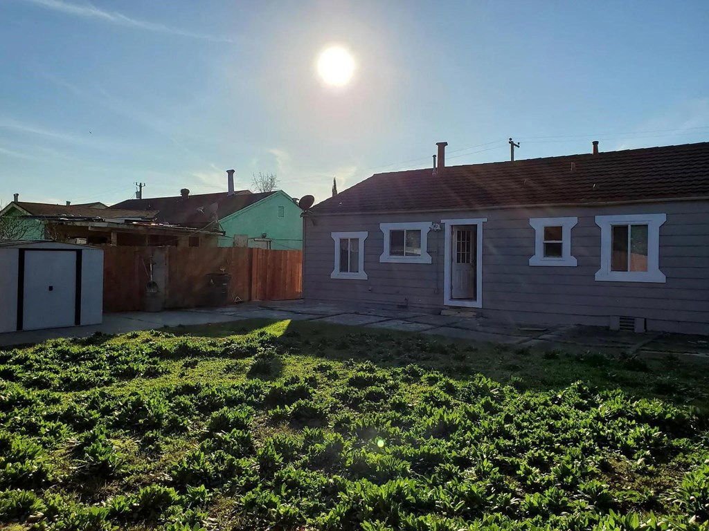 the backyard of a house with the sun above it