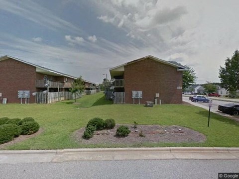a building on the side of a street with a lawn