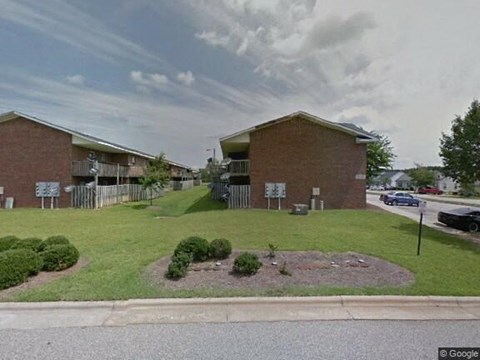a building with a lawn and a parking lot