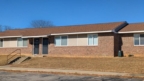 A brick building with a black door and windows.