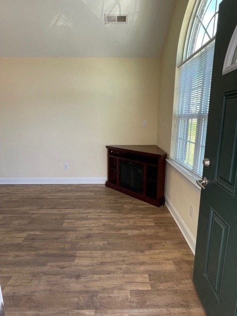 A room with a green door and a window with blinds.