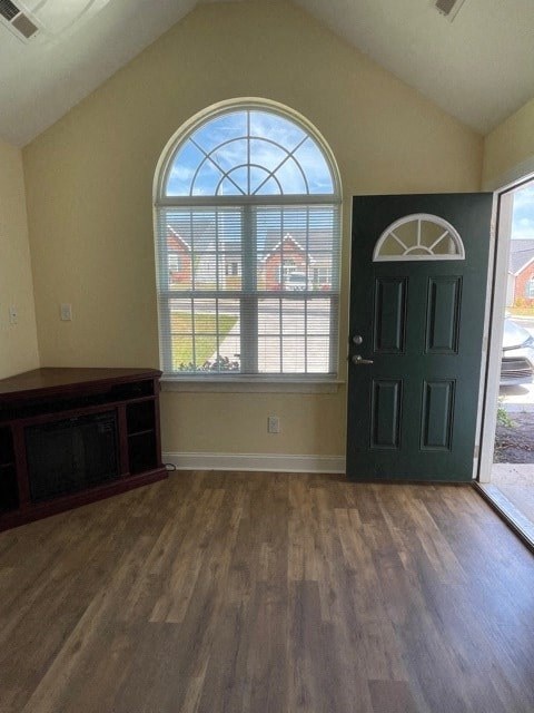 A room with a large arched window and a green door.