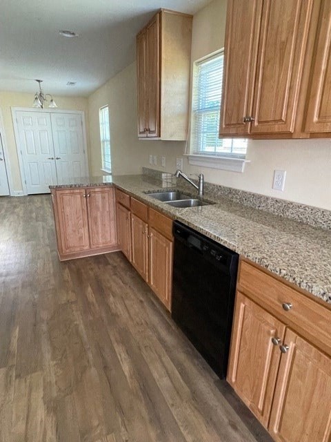 A kitchen with wooden cabinets and a black dishwasher.