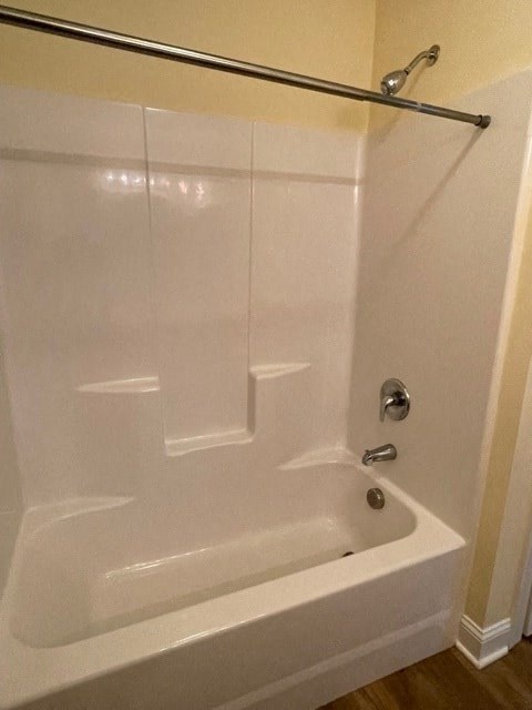 A white bathtub with a silver faucet and a silver shower rod.