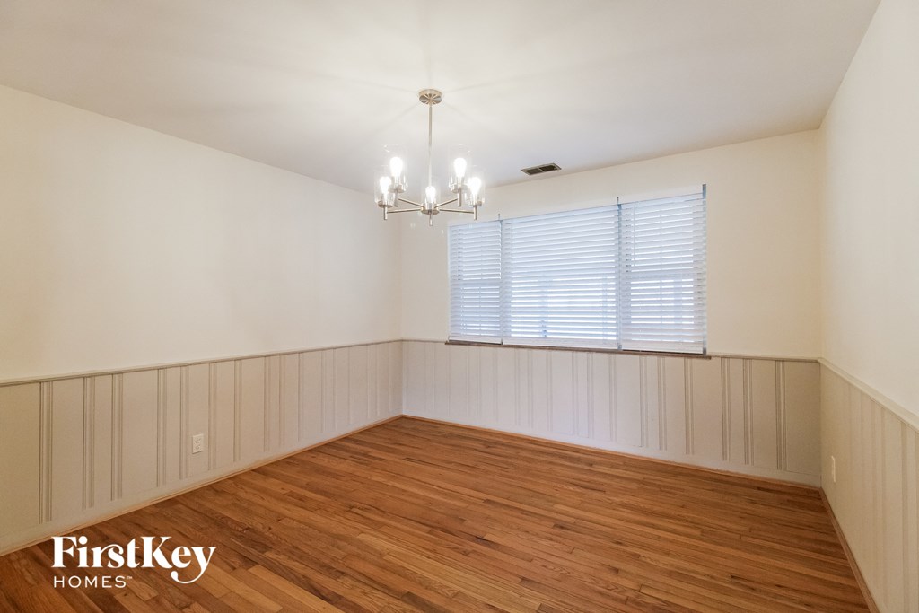 A room with wooden floors and a chandelier.