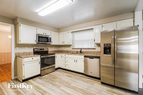 A kitchen with wooden floors and stainless steel appliances.