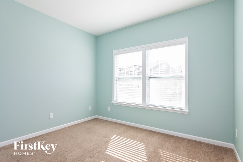 A room with a window and a carpet on the floor.