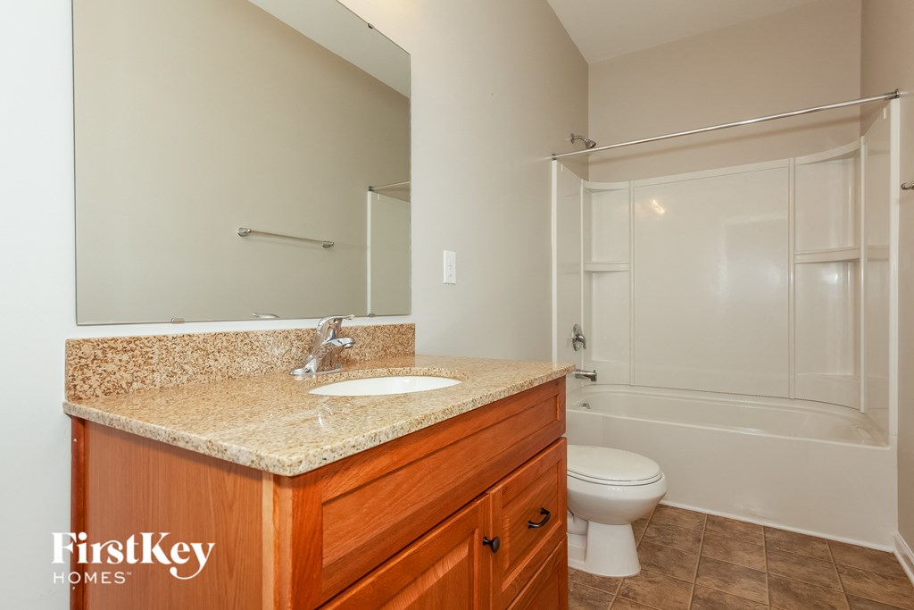 A bathroom with a sink, toilet, and bathtub.