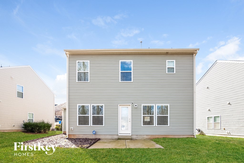 A grey house with a white door and windows is shown with the words "First Key Homes" on the bottom left.