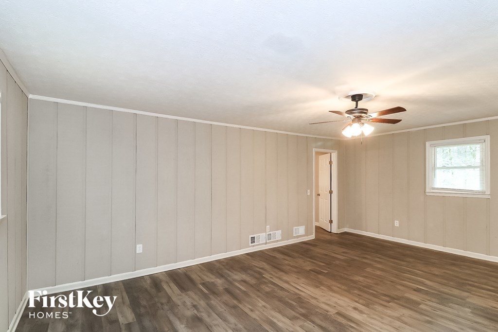 the living room of a house with wood floors and a ceiling fan