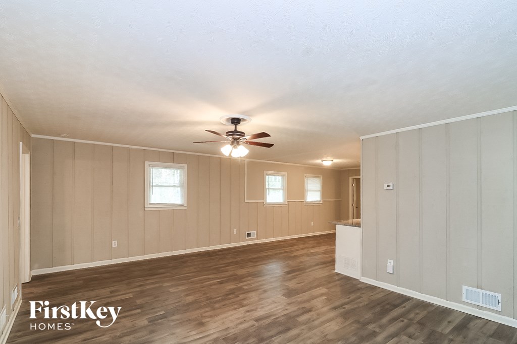 the living room of an empty house with a ceiling fan