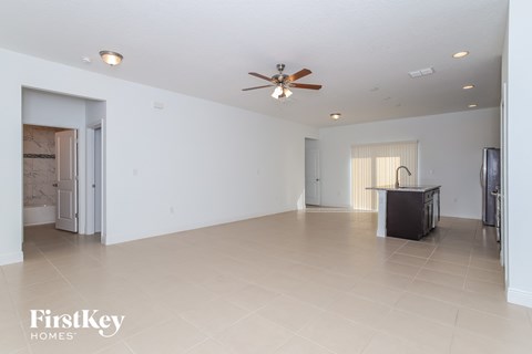A spacious room with a ceiling fan and a television.