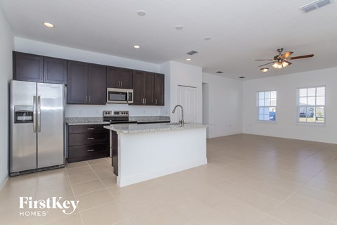 A spacious kitchen with a refrigerator, microwave, and oven.
