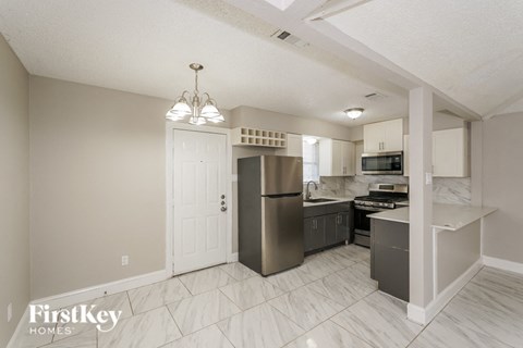 a kitchen with a stainless steel refrigerator and a sink