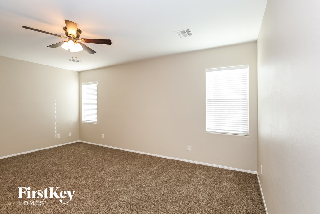 a room with carpet and a ceiling fan