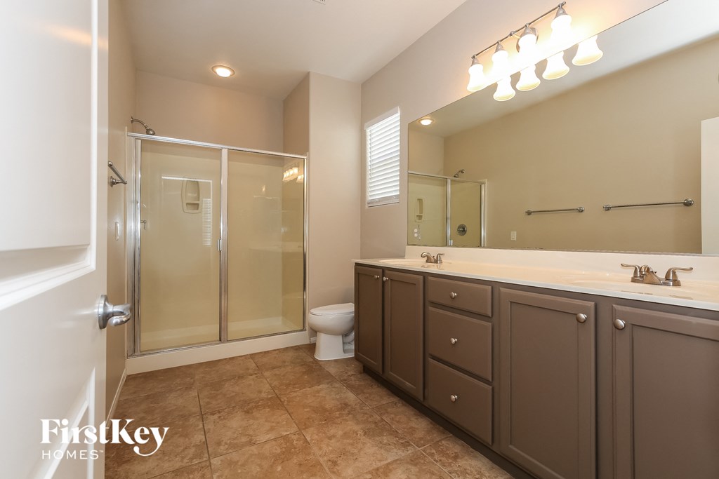 a bathroom with a large mirror and a shower and a toilet
