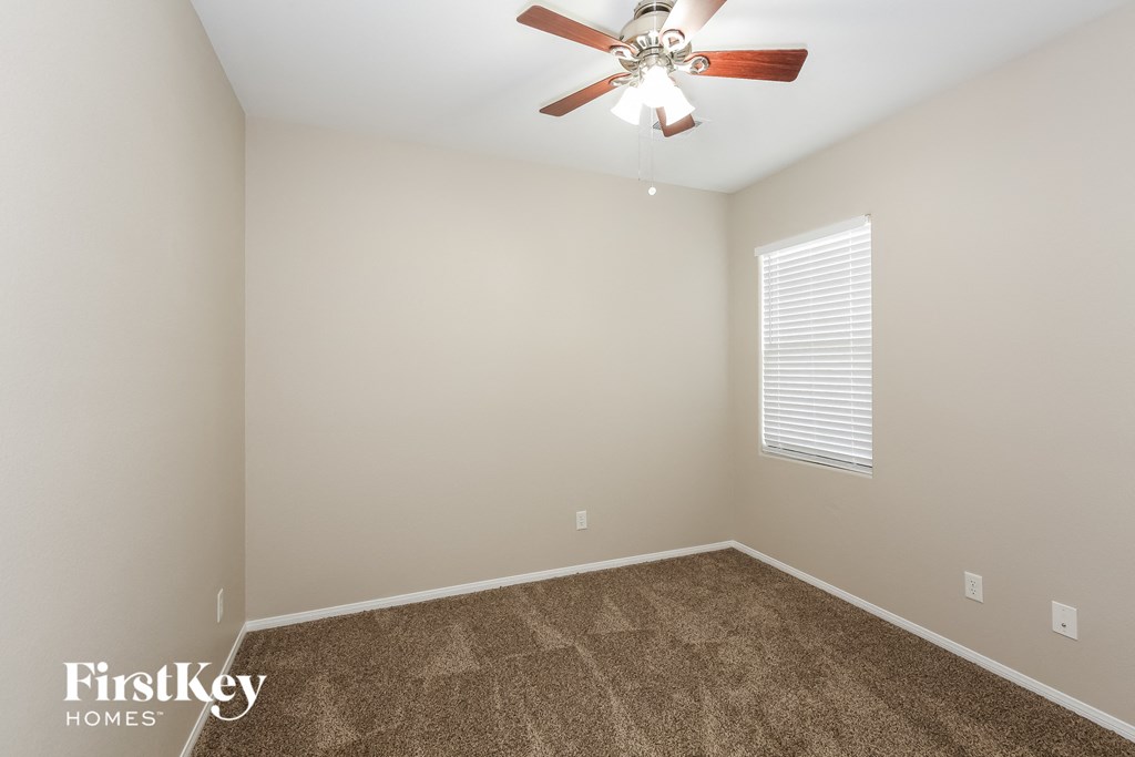 a room with carpet and a ceiling fan