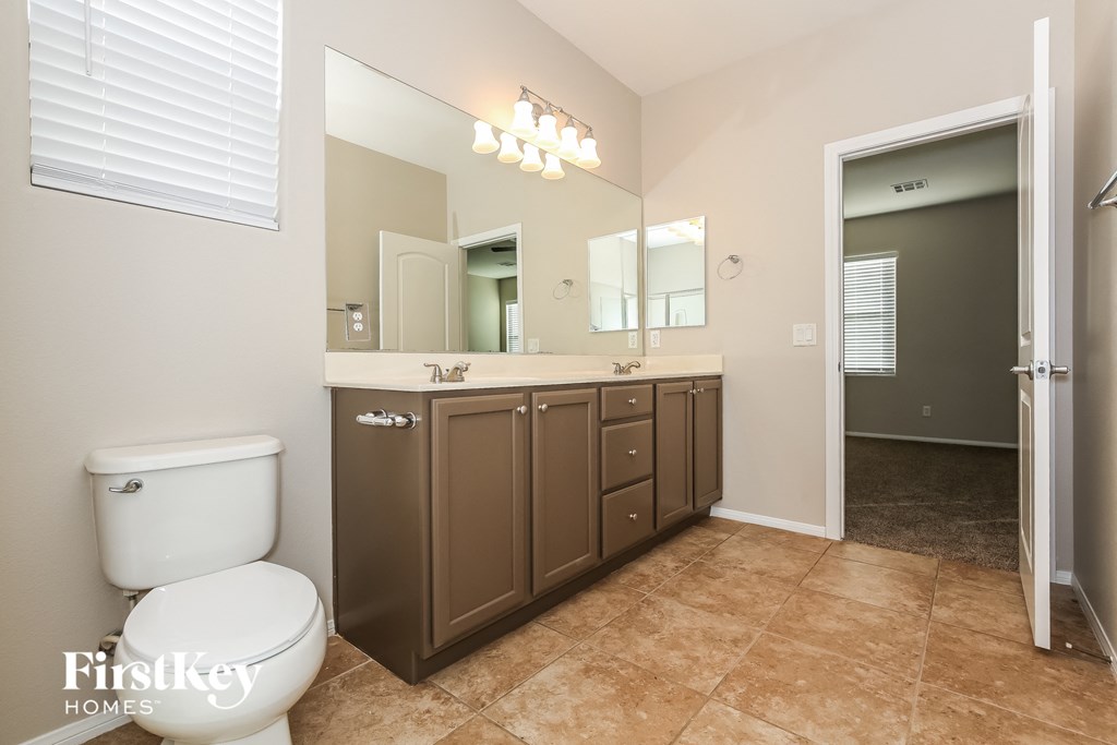 a bathroom with a toilet and a sink and a mirror